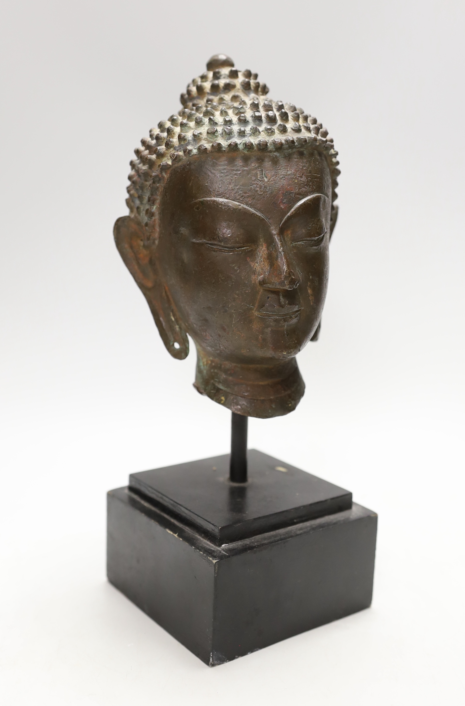 A Thai bronze Buddha head, cast bronze on stand, 17th/28th century century, vendor states belonged to Alexander McQueen, 27cm